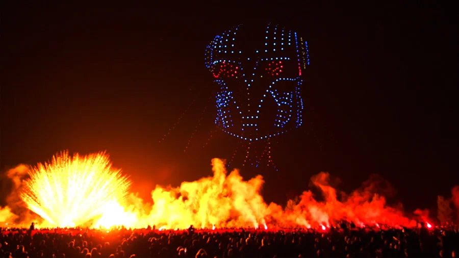 Robot lumineux évoluant sur scène lors d'un spectacle pyrotechnique