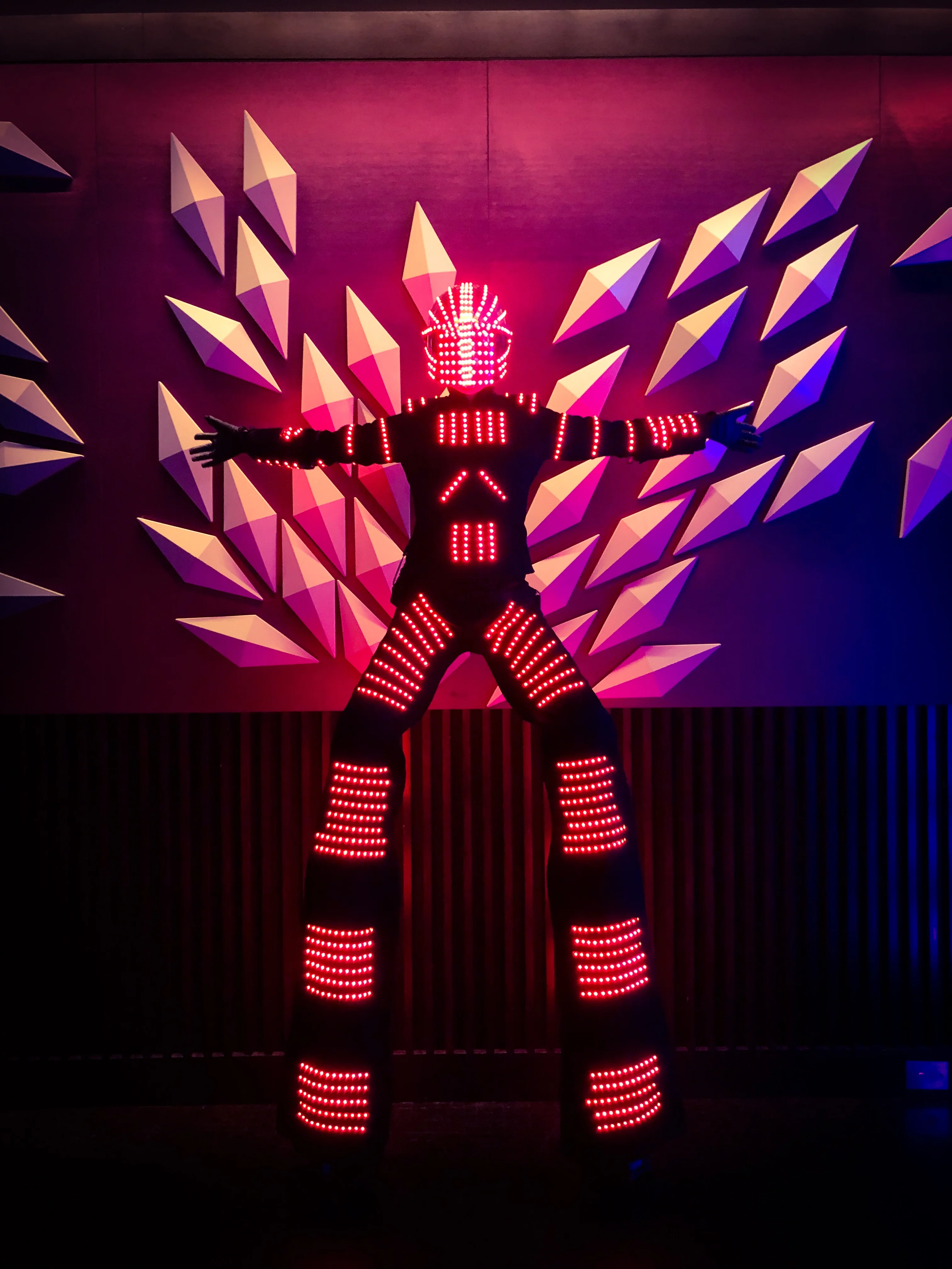 Robot sur échasses lumineuses lors d'une performance scénique