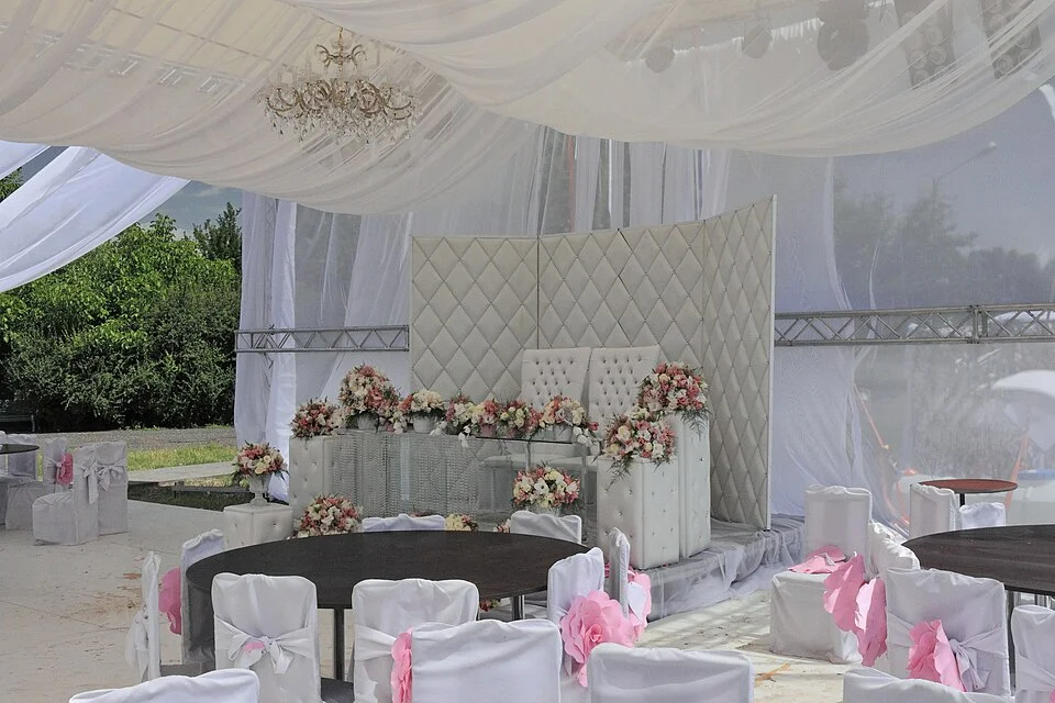 Tente de réception blanche montée en extérieur pour un mariage